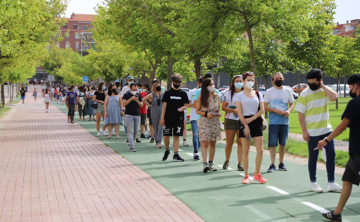 Cola de jóvenes esperando para entrar en el pabellón para el cribado.
