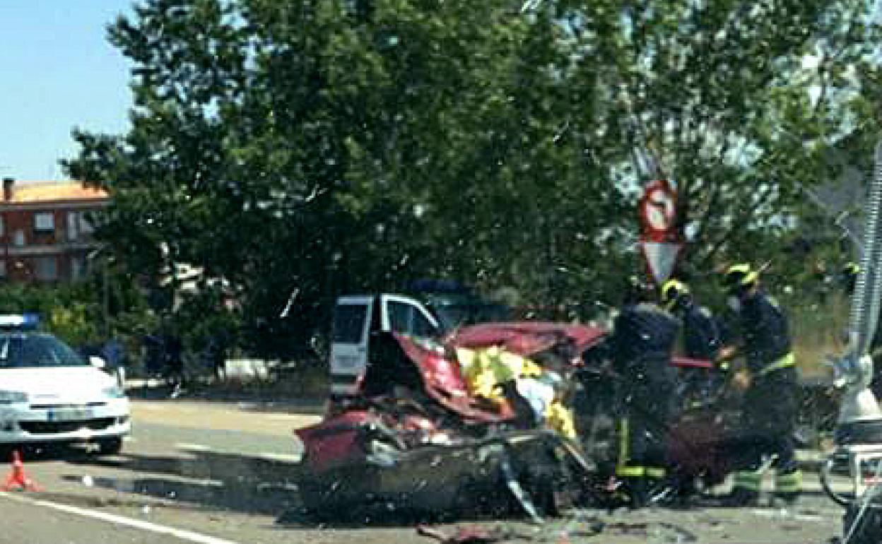 Los Bomberos trata de excarcelar el cadáver del vehículo siniestrado. 