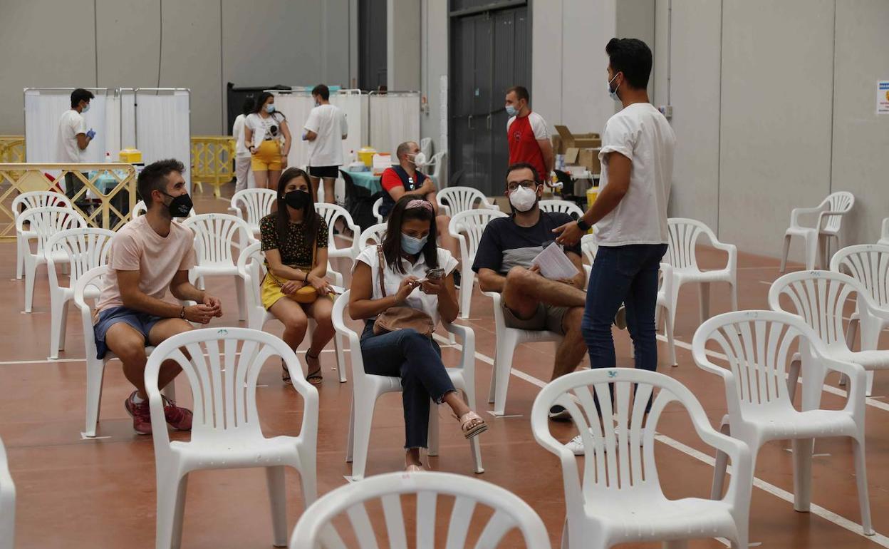 Jóvenes esperan sus quince minutos tras ser vacunados en Peñafiel.. 