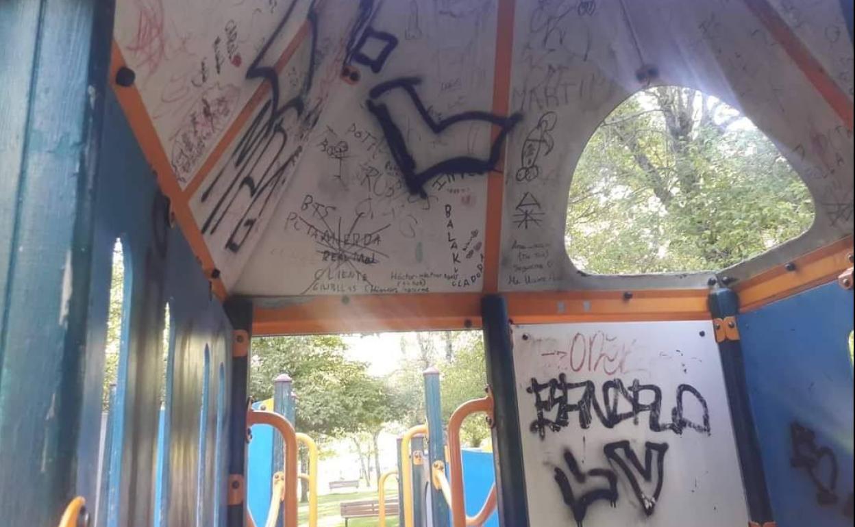 Pintadas y destrozos varios ocasionados en el interior de uno de los juegos inclusivos del parque que hay en la Pradera del Hospital de La Granja. 