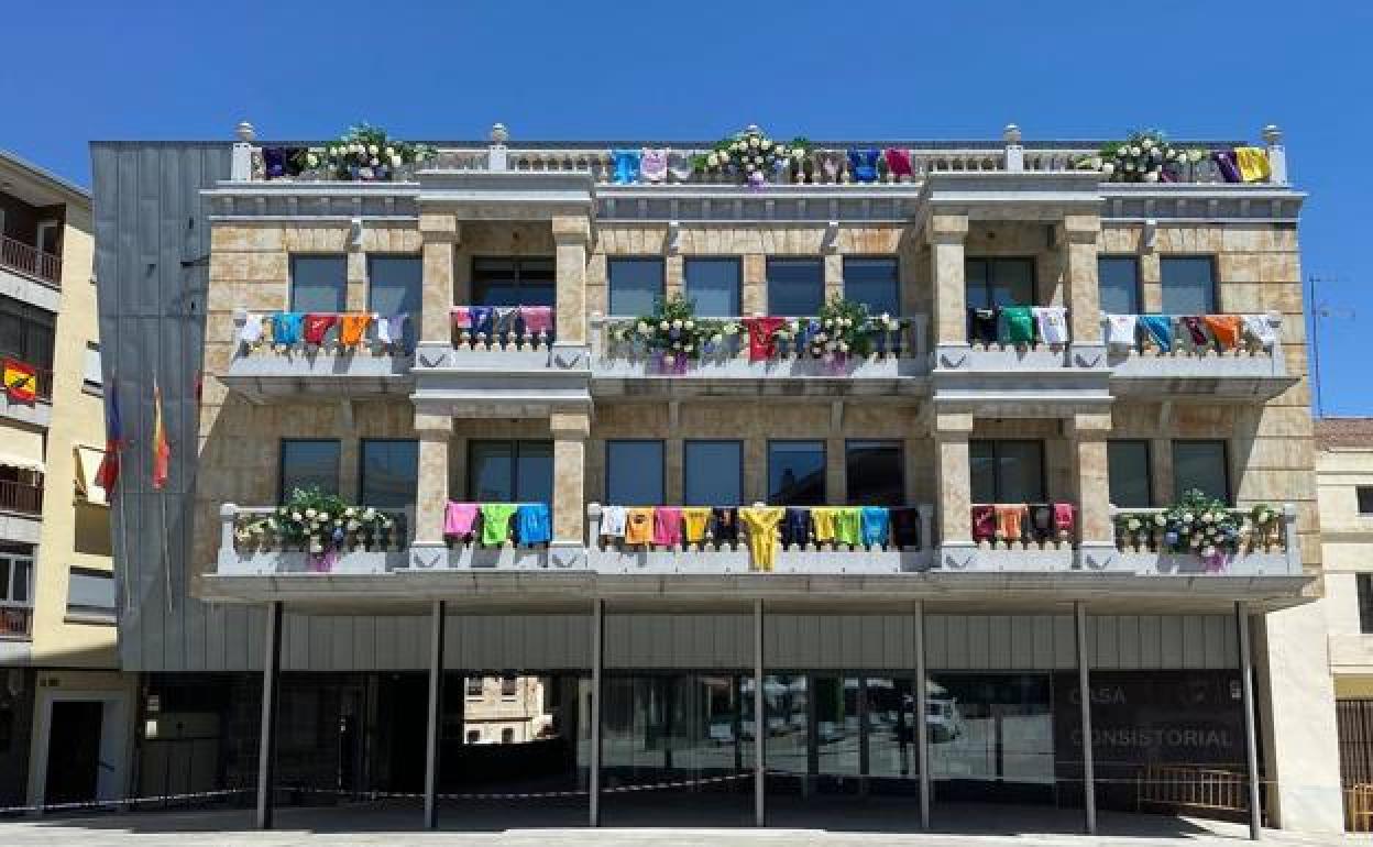 Fachada del Ayuntamiento de Guijuelo adornada con las camisetas de las peñas. 