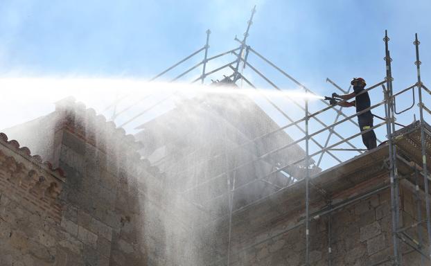 Un bombero trabaja esta tarde desde un andamio colocado para las obras que se acometían en la cubierta. 