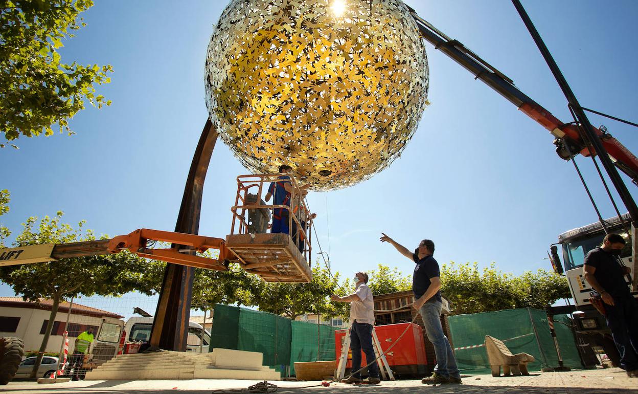 Colocación de la pieza que representa al sol realizada con 1.200 manos entrelazadas. 