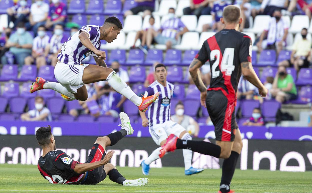 Marcos André salva con un salto la entrada de un jugador del Rayo en el partido del Trofeo, con Olaza al fondo observando la jugada. 