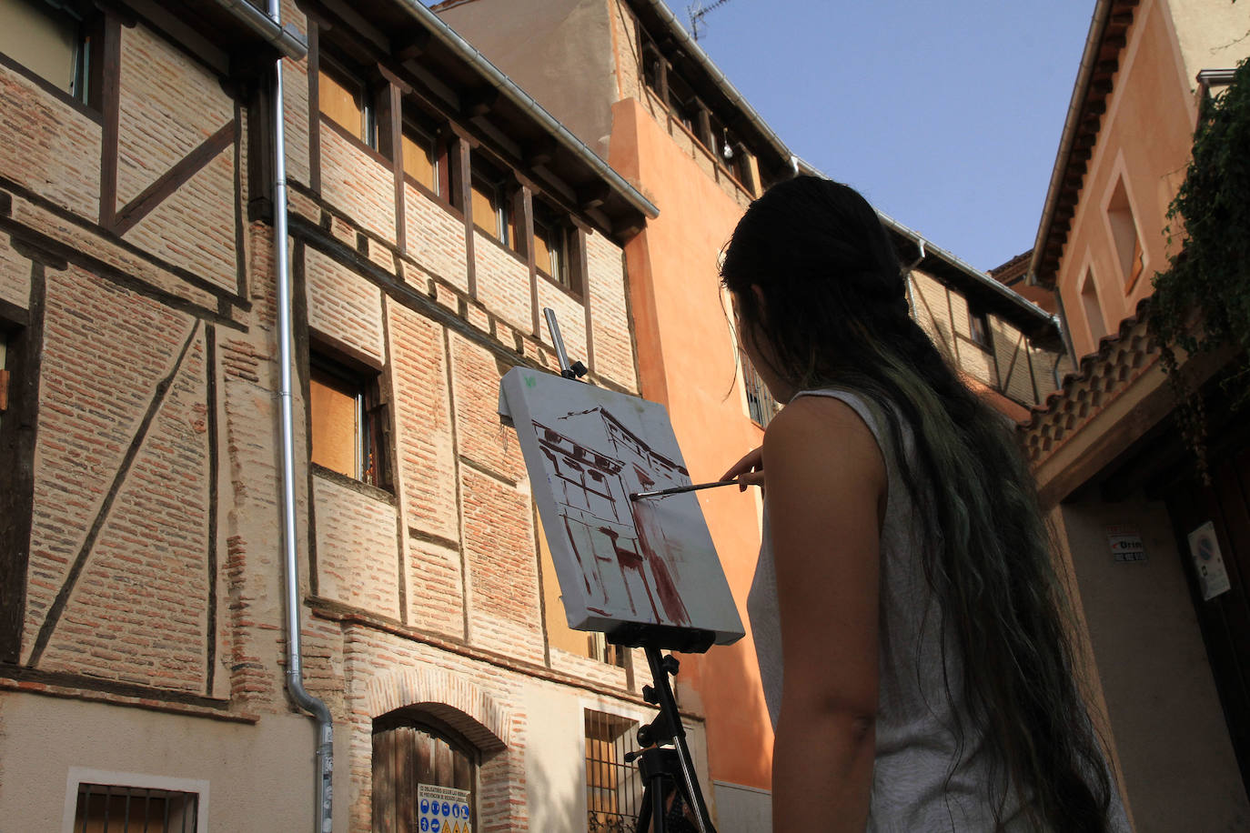 Una participante en el curso pinta una casa de Segovia.