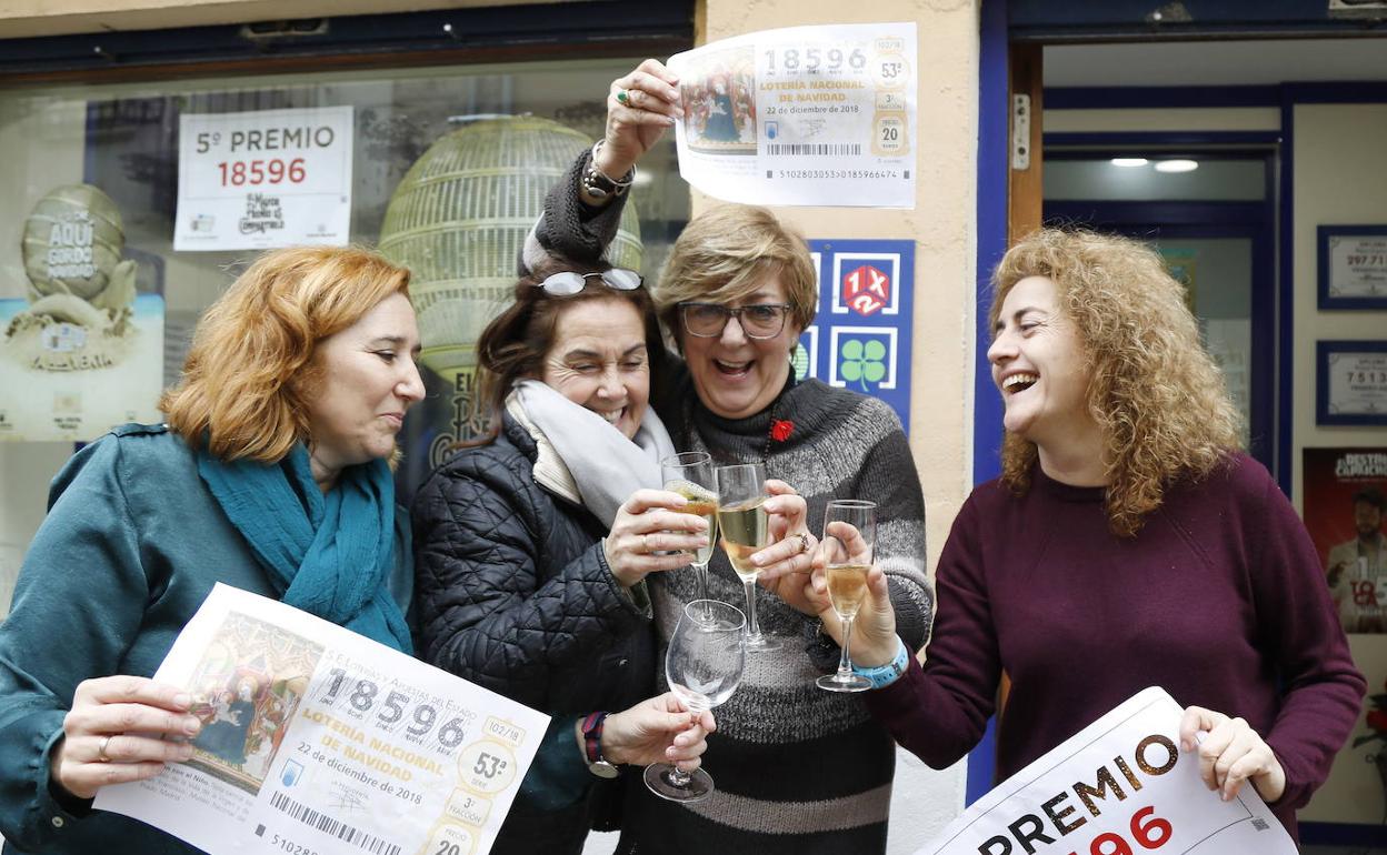 La lotera, Ana Gago, segunda por la derecha, festeja un quinto premio repartido en su administración en la lotería de Navidad de 2018. 