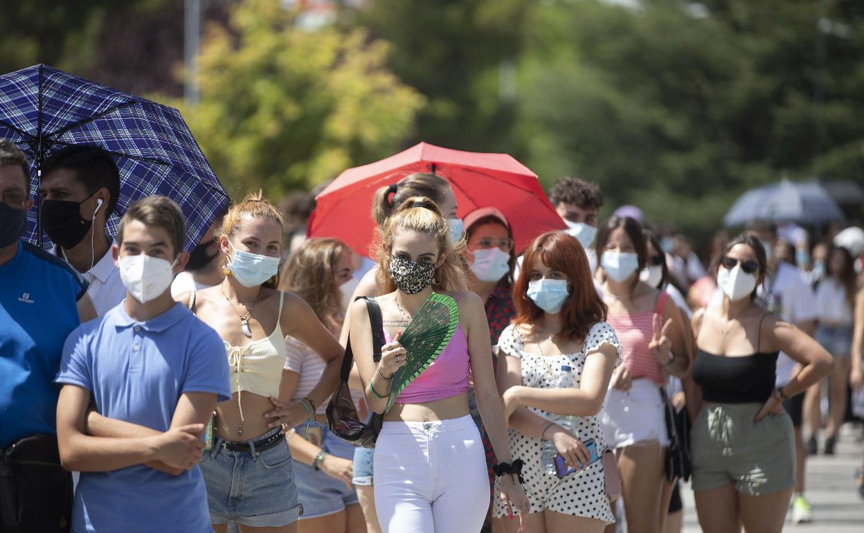 Jóvenes esperan su turno en el exterior del centro de vacunación en el auditorio Miguel Delibes. 