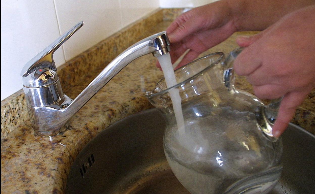 Un vecino llena una jarra con agua del grifo de su casa.