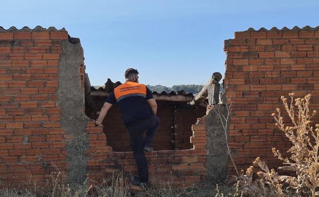 Un miembro de Protección Civil se asoma al interior de una construcción en ruinas durante las tareas de búsqueda.