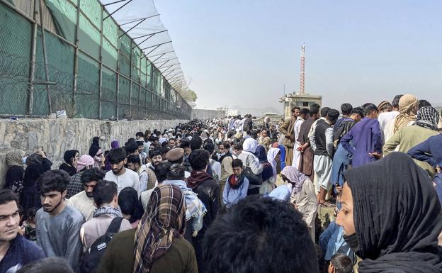 Ciudadanos esperan para huir en el aeropuerto de Kabul. 