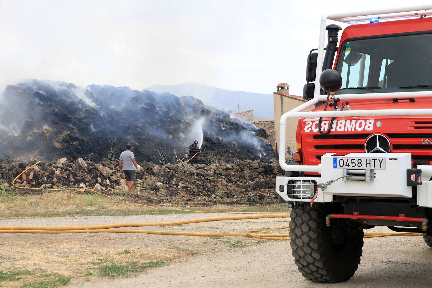 Un camión del parque de bomberos de la capital y agentes del cuerpo sofocan un incendio de pacas de paja en Trescasas el año pasado.