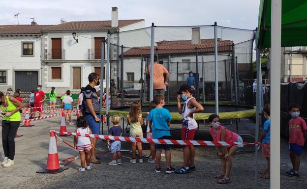 Varios niños esperan para saltar en las camas elásticas. 