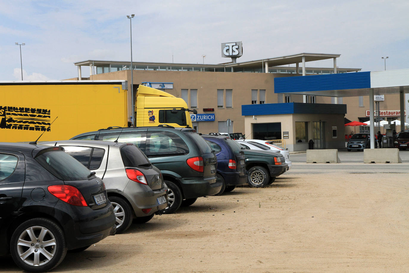 Vehículos estacionados en el parte de tierra del aparcamiento del Centro de Transportes de Segovia.