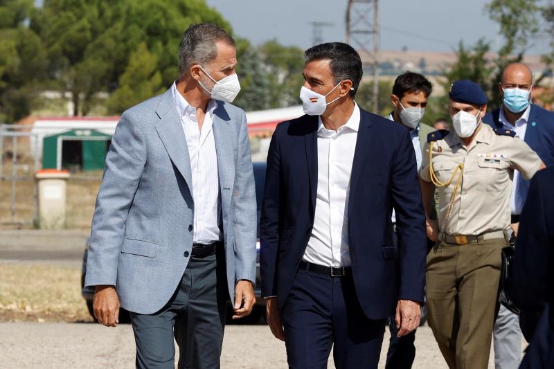 El rey Felipe VI y el presidente del Gobierno, Pedro Sánchez, conversan durante su visita este sábado al centro de acogida temporal instalado en la base de Torrejón.