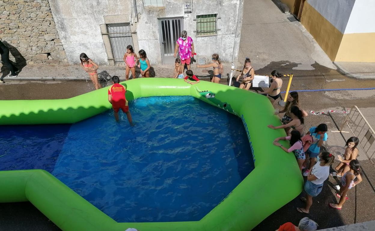 Varios niños esperan para tirarse por el tobogán acuático. 