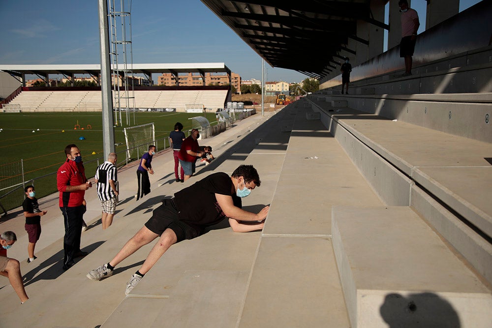 Los jugadores entrenan a las órdenes de Dani Mori mientras los voluntarios del club preparan las gradas del Reina Sofía