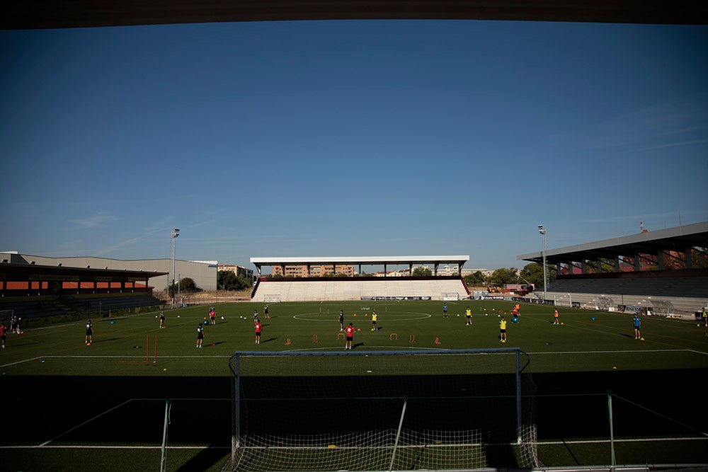 Los jugadores entrenan a las órdenes de Dani Mori mientras los voluntarios del club preparan las gradas del Reina Sofía