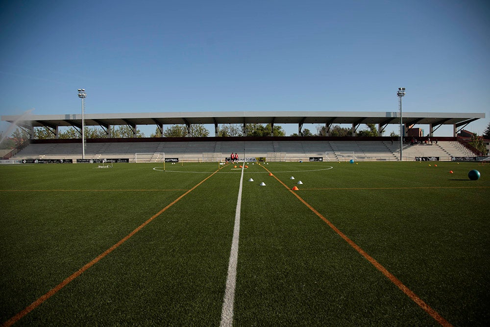 Los jugadores entrenan a las órdenes de Dani Mori mientras los voluntarios del club preparan las gradas del Reina Sofía