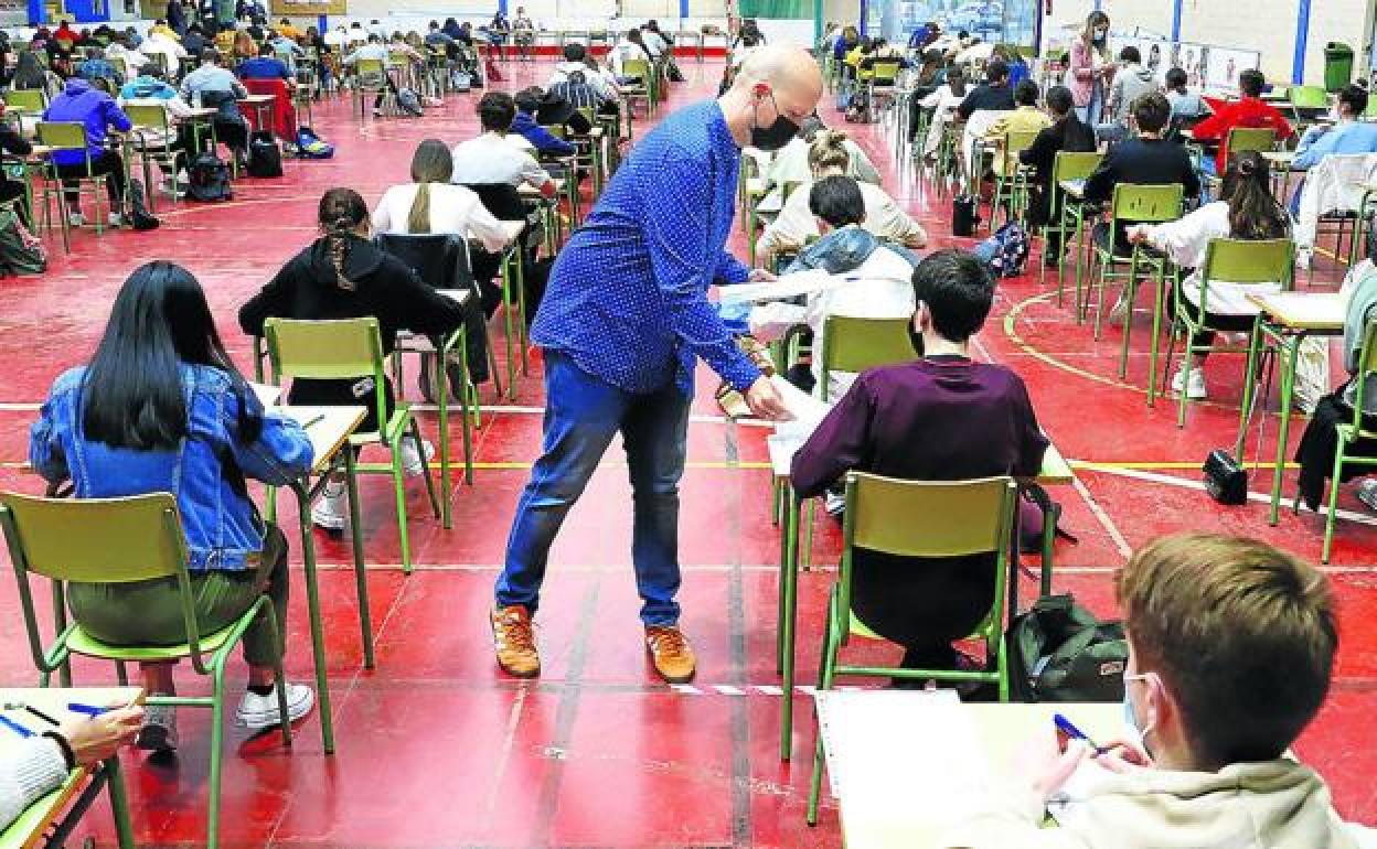 Un profesor reparte los examenes. 