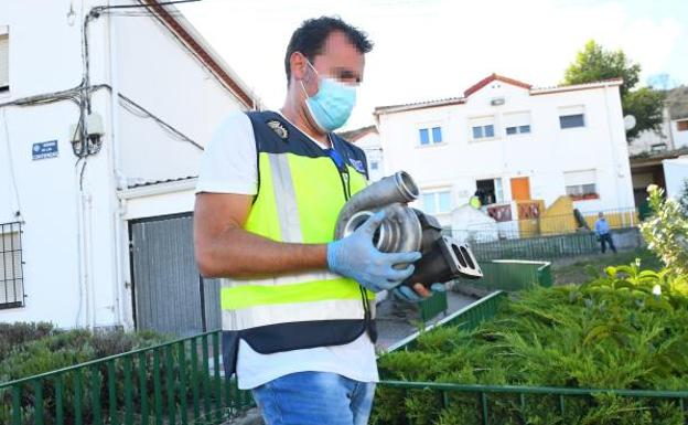 Un agente porta una pieza de motor intervenida en la vivienda del sospechoso. 