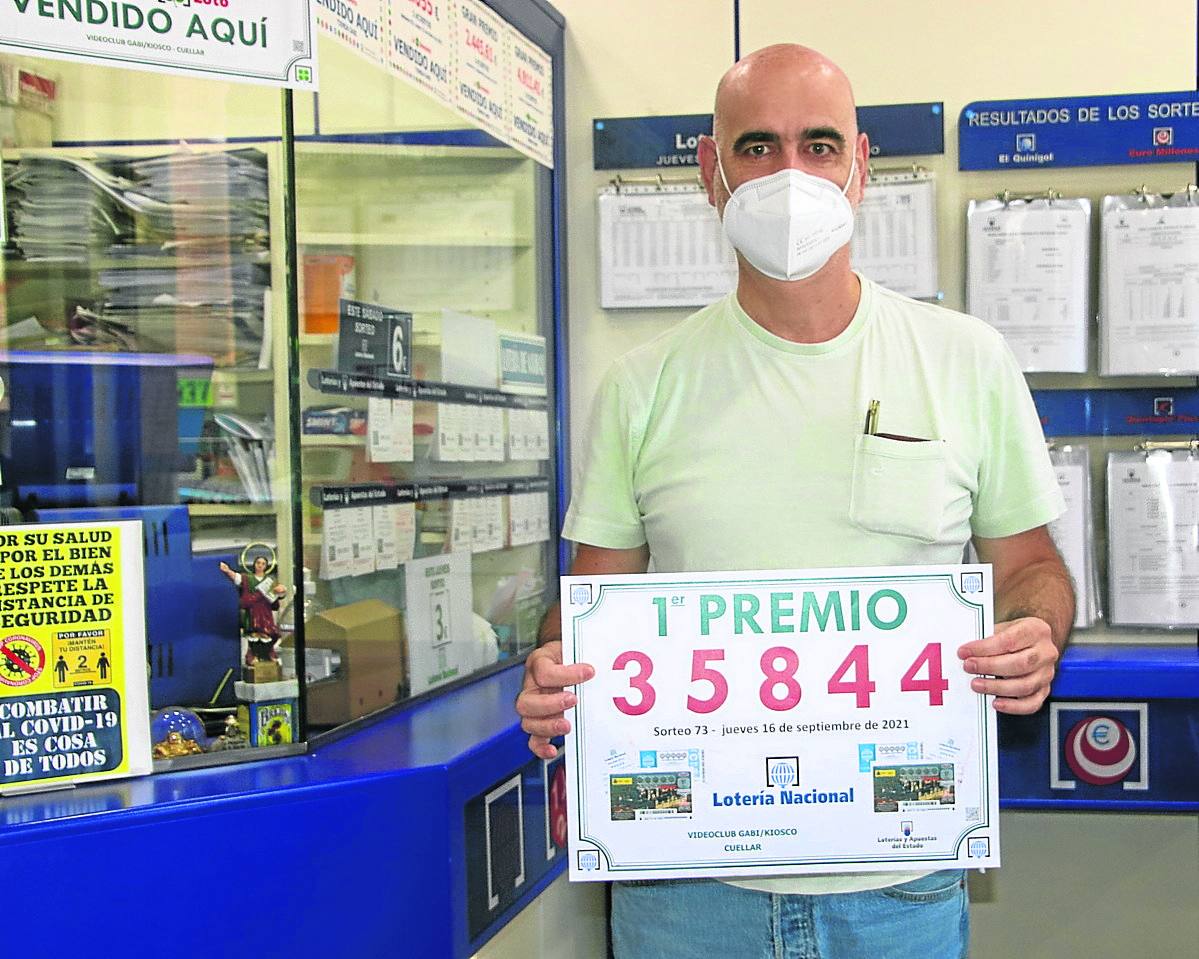 Fernando Senovilla exhibe el número premiado, en su establecimiento de la calle Resina. 