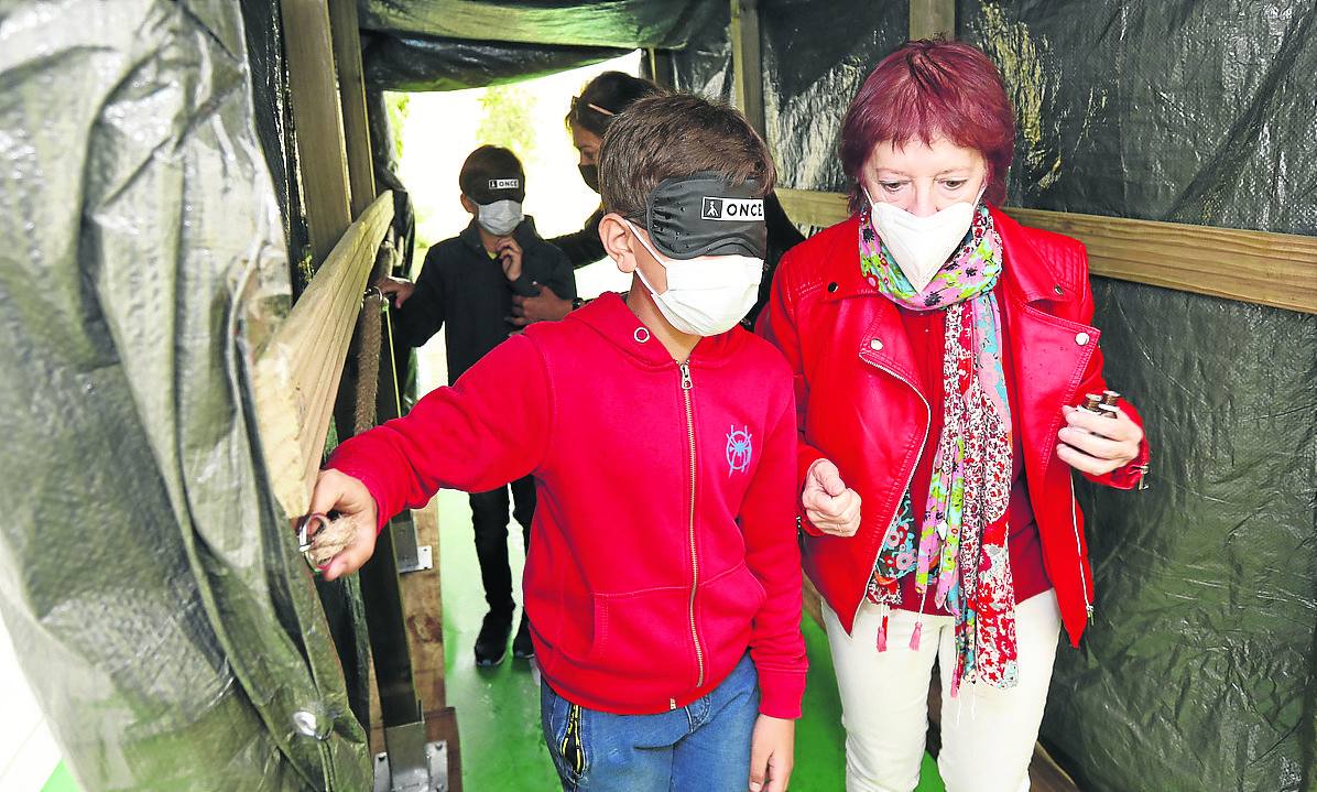 Los voluntarios conducen a los niños por el túnel de los sentidos instalado en el Salón.