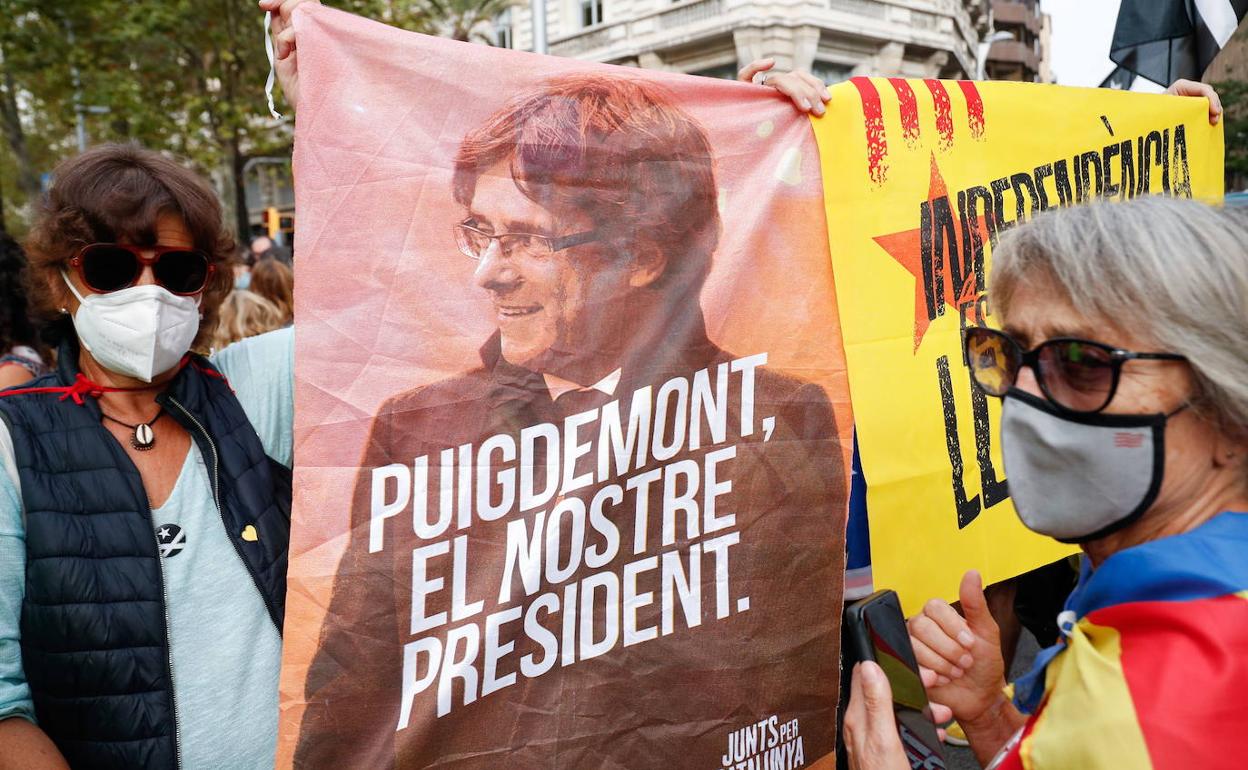 Dos mujeres junto a una pancarta de apoyo a Carles Puigdemont.