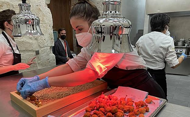 Imagen principal - Arriba, el equipo de Trigo y Abadía colocan algunos de los bocados antes de ofrecérselos a los invitados. Abajo, el chef Víctor Martín con el catador Luis Gutiérrez en las cocinas de Refectorio, y el periodista Luis Cepeda prueba el huevo con conejo, setas y patata. 