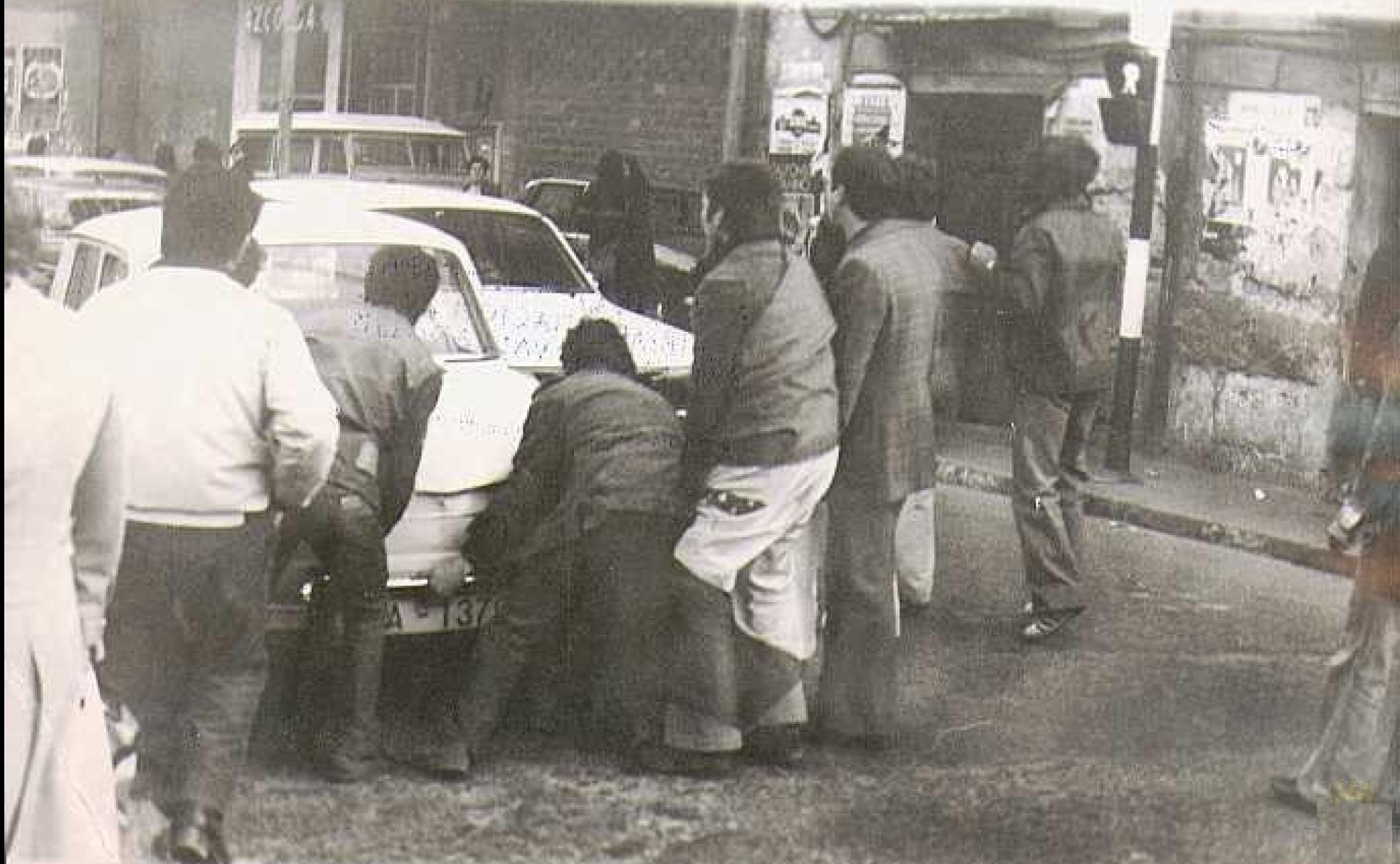 Trabajadores en huelga preparando una barricada en la calle a base de automóviles. 