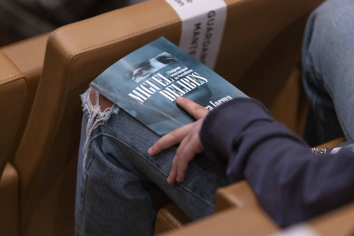 Un joven con el programa del congreso.