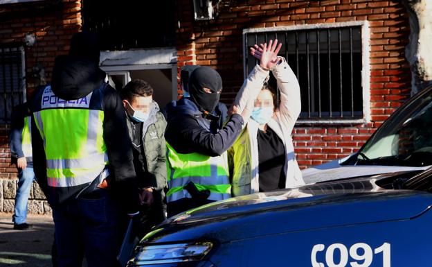 Los agentes trasladan esposados a dos de los detenidos en la plaza del Esla. 