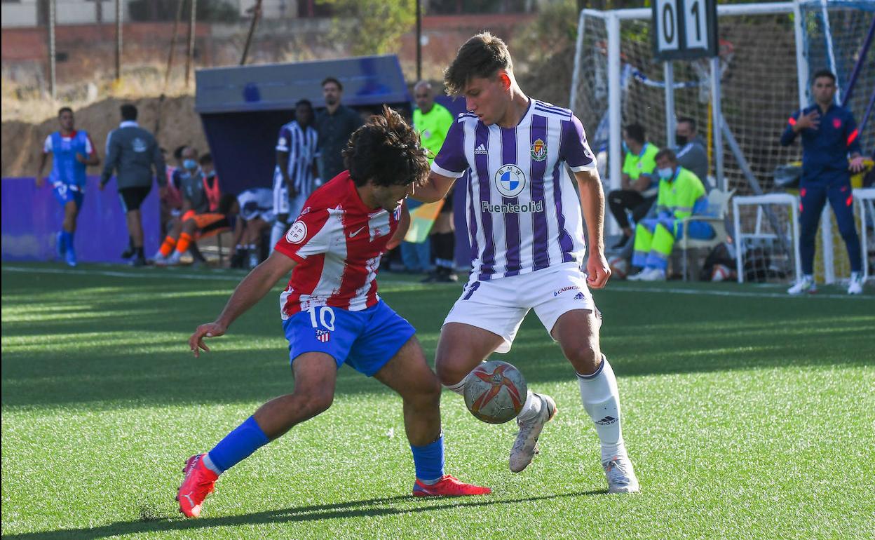 Álvaro intenta progresar con un regate ante la presión de Currás, autor del primer tanto rojiblanco de penalti