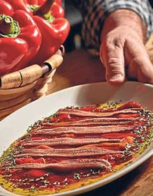 Imagen secundaria 2 - Arriba, fachada de El Pinchín; debajo, a la izquierda, ensalada de verduritas y bonito, y a la derecha, bandeja de anchoas con pimientos.