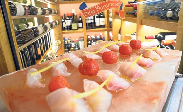 Imagen principal - Arriba, sashimi de dorada en piedra de sal con tomates cherry asados; debajo, a la izquierda, el restaurante dispone de una amplia carta de vinos en su bodega, y la derecha, camarón mexicano: tartar de carabineros y guacamole. 