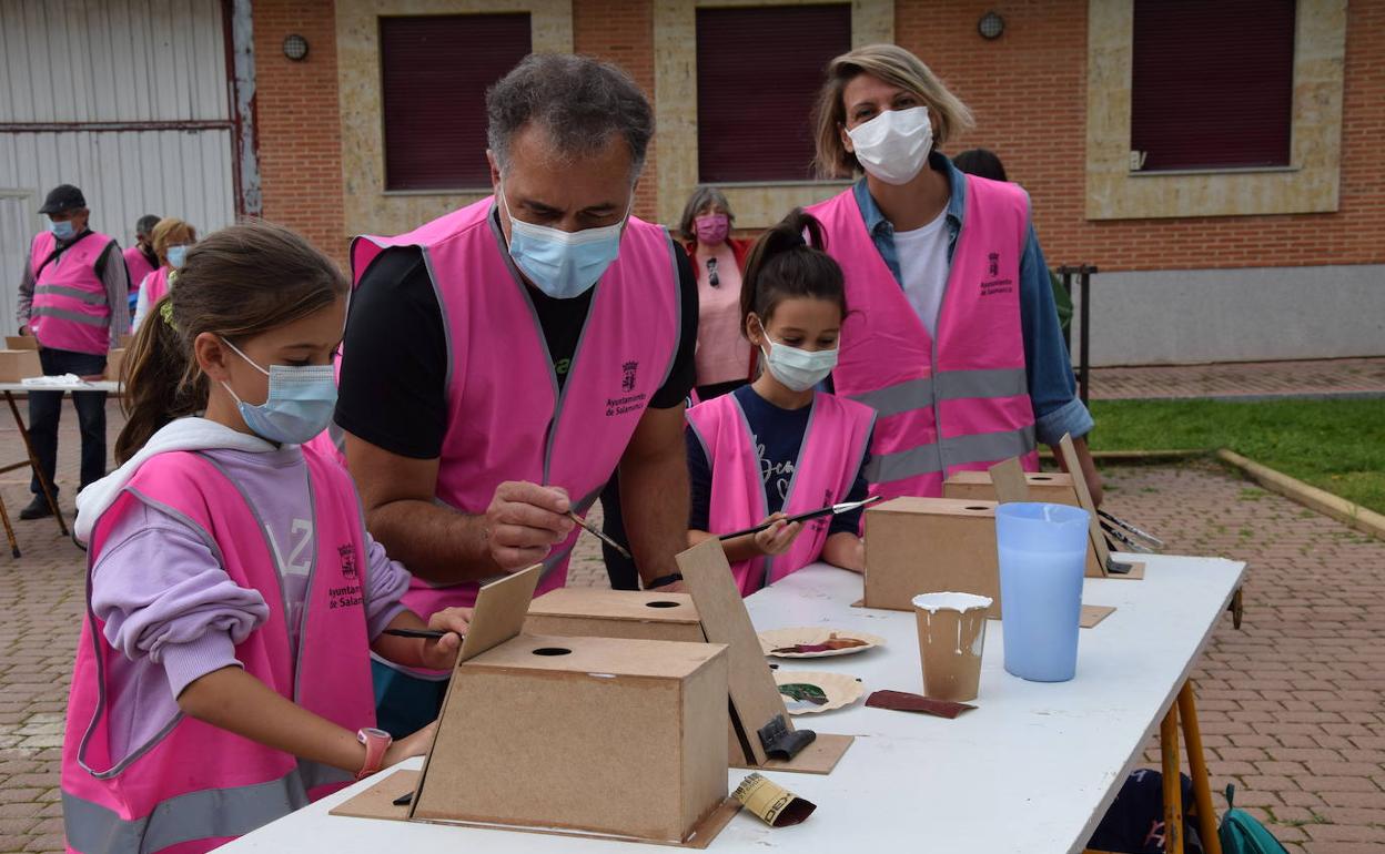 Blanca y Julia pintan las cajas nido acompañadas por sus padres durante la actividad 'VoluntaS'.