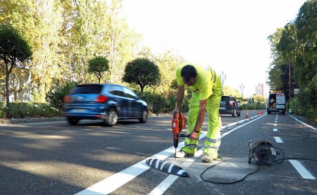 Un operario coloca los separadores en el nuevo tramo del carril bici del Paseo de Zorrilla. 