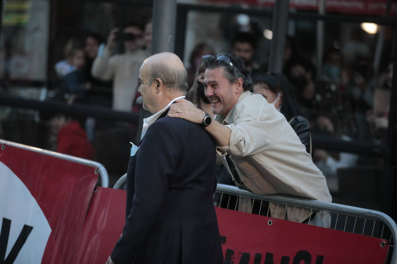 Al actor, Antonio Resines, saluda a un fan que le llamaba desde fuera de la alfombra.