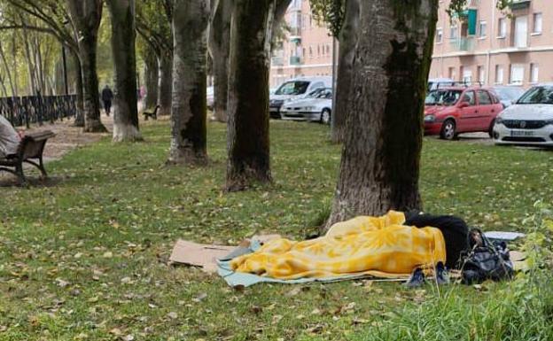 Imagen principal - Una persona duerme en los jardines del paseo de Extremadura y detalles, debajo, de basura en el patio de un bloque de viviendas y de una jeringuilla encontrada cerca del albergue. 