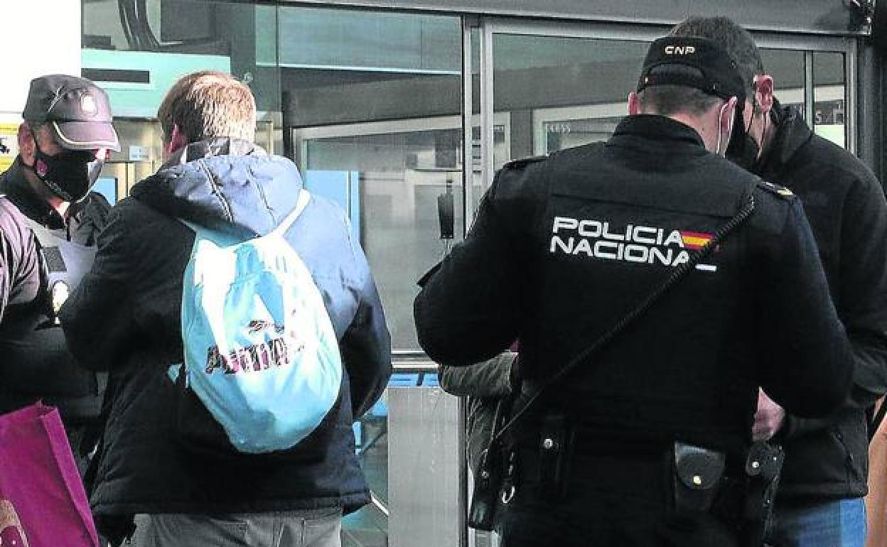 Policías nacionales piden documentación a viajeros en la estación del Ave durante la pandemia. 