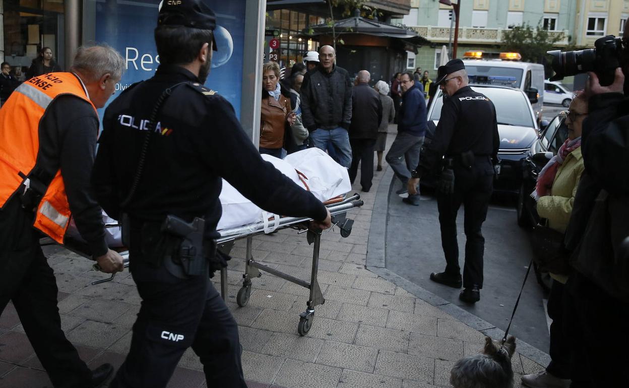 Los forenses trasladan el cadáver de la mujer asesinada en su piso de la Plaza Circular. 