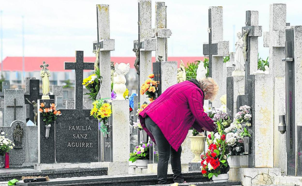 Una mujer coloca flores en una tumba del Cementerio de El Carmen en Valladolid. 