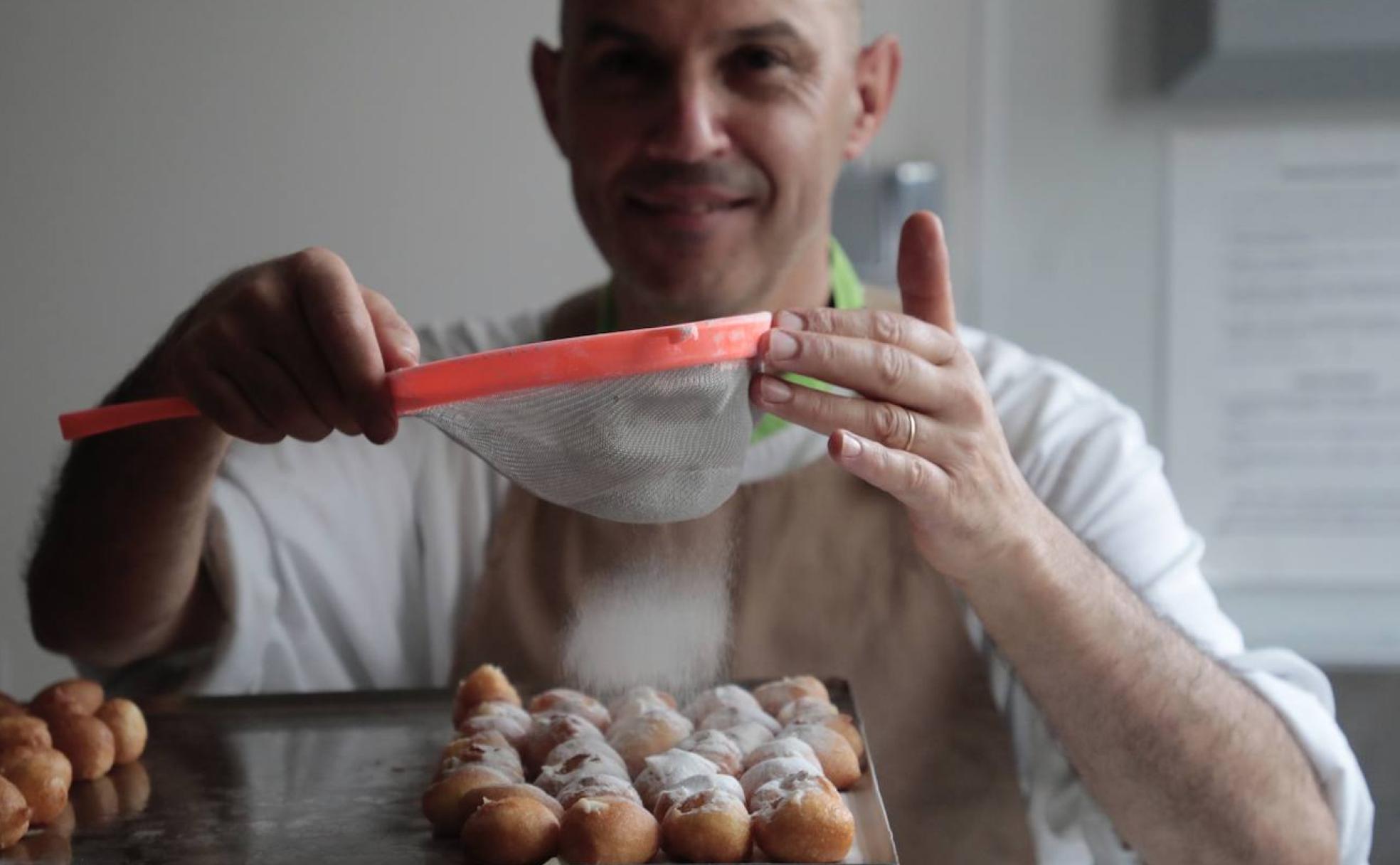 Marcial Villegas decora con azúcar glas unos apetitosos buñuelos recién hechos en el obrador de la confitería Menta y Chocolate de Tudela de Duero.