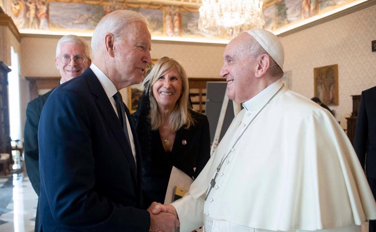 Joe Biden estrecha la mano al papa Francisco.