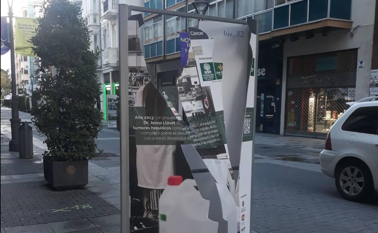 Uno de los paneles de la muestra de la Asociación Contra el Cáncer destrozado en la calle Santiago. 