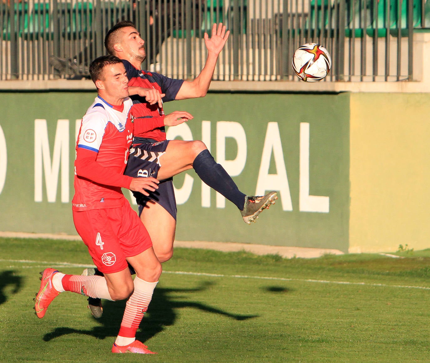 Jugadores de la Gimnástica y del Móstoles forcejean en el saque de un balón parado. 