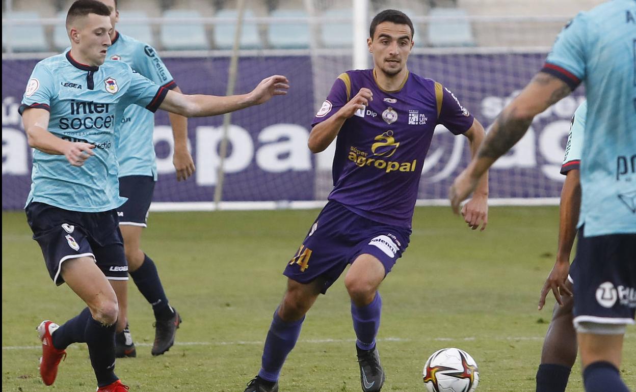 Javi Bueno conduce el balón ante varios rivales del Langreo. 