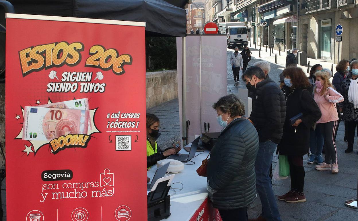 Ciudadanos hacen cola en una caseta de expedición de bonos de descuento en la campaña 'Son compras y mucho más'. 