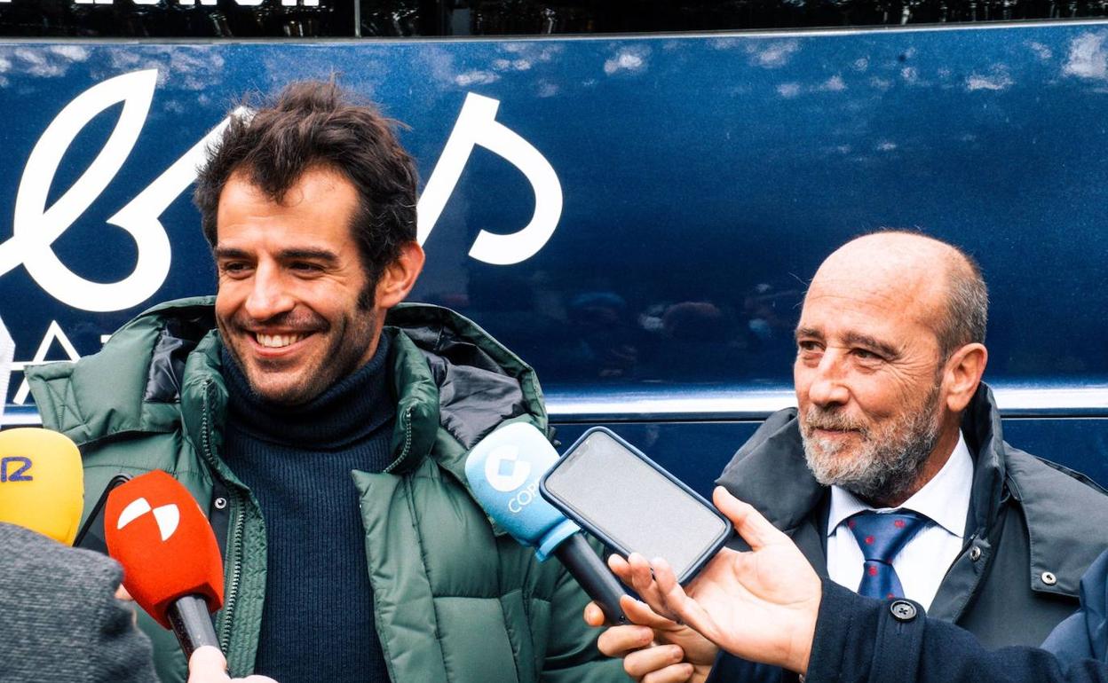 Merino y Valentín Gamazo atienden a la prensa delante del nuevo autocar. 