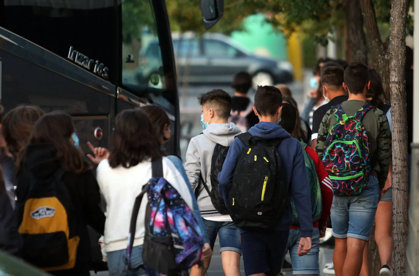 Alumnos de secundaria se disponen a tomar el transporte escolar en Palazuelos de Eresma, Segovia.