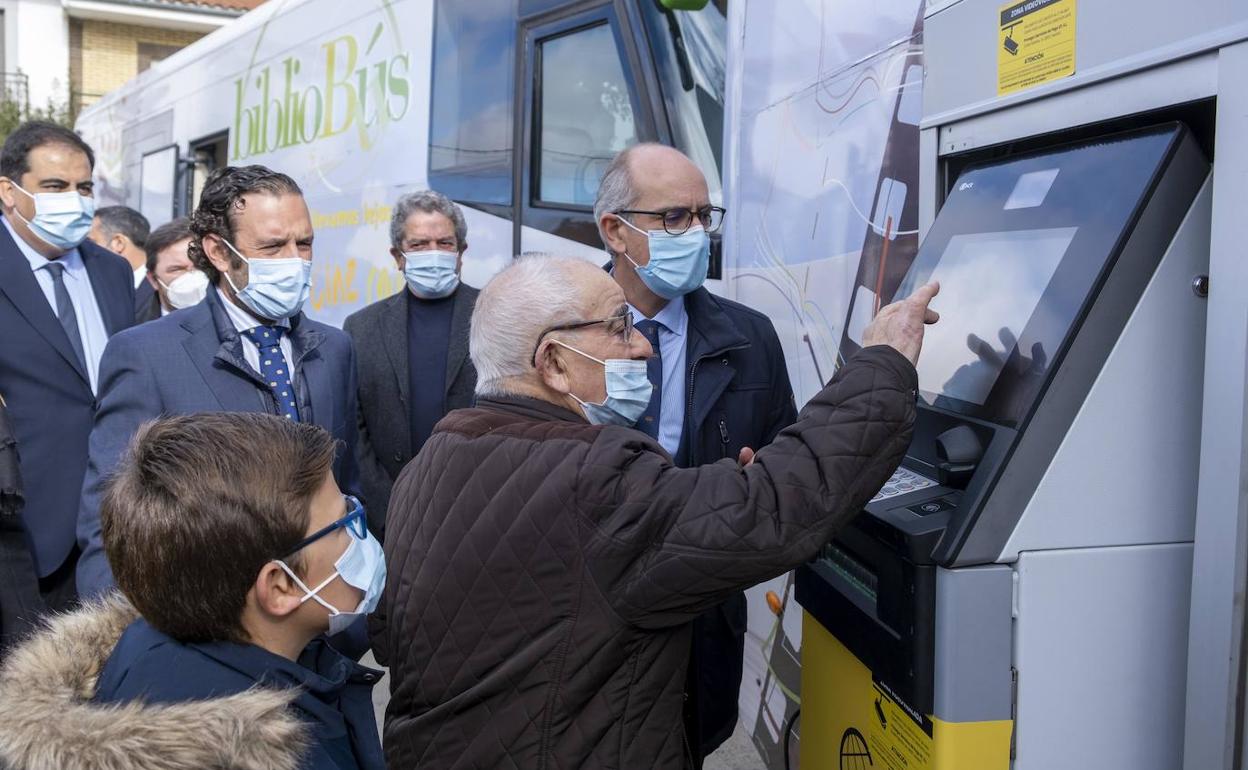 Manuel Benito, de 88 años de edad, utilizando ayer el 'bibliocajero' en presencia del presidente de la Diputación, Javier Iglesias. 